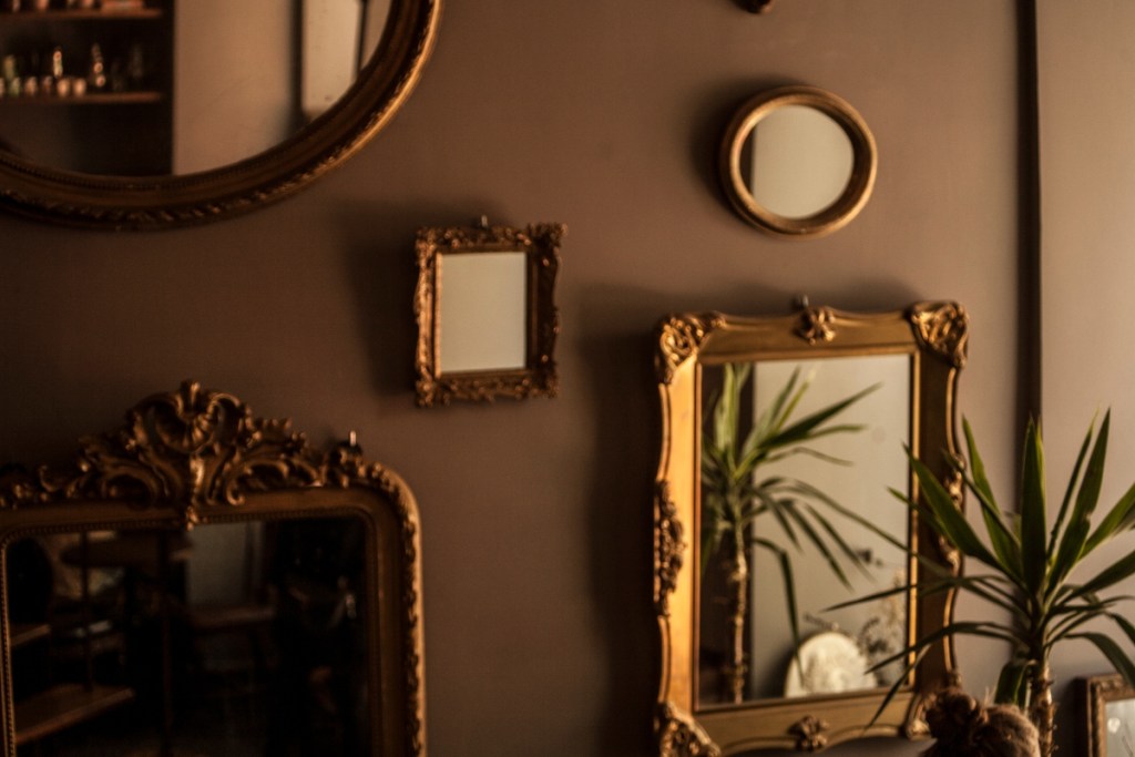 Multiple antique mirrors on gallery wall