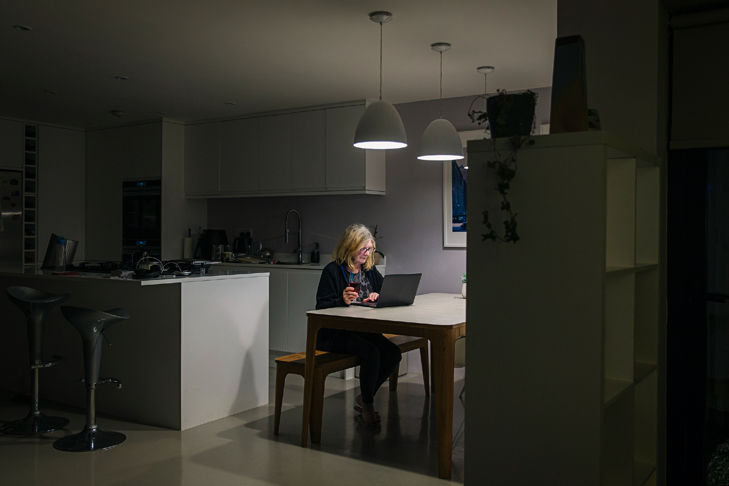 Woman working in home with open floorplan.