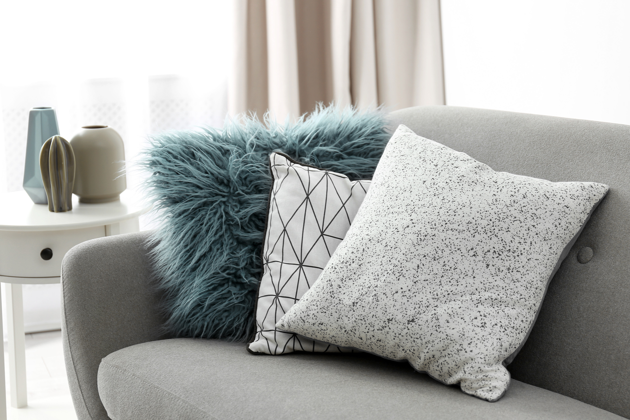 Patterned and faux fur throw pillows on couch