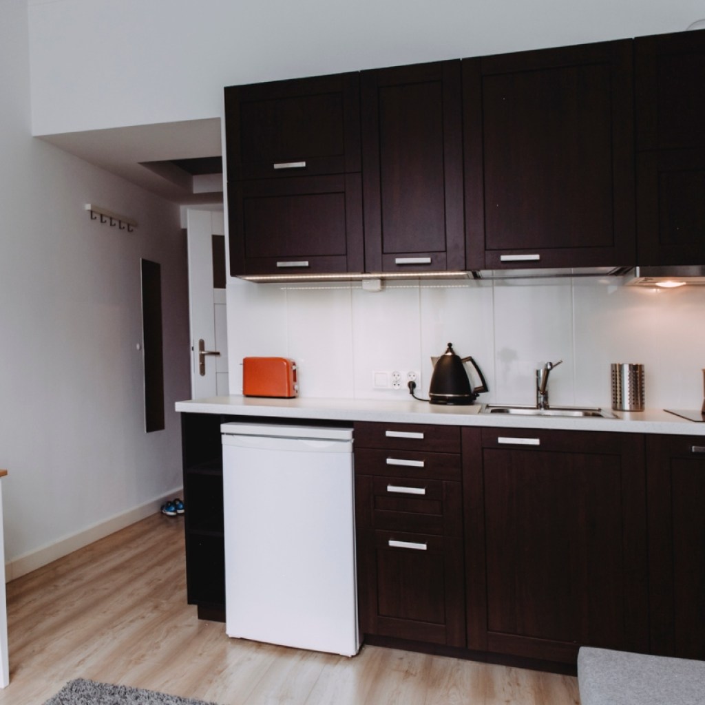 small kitchenette in basement with dark cabinets
