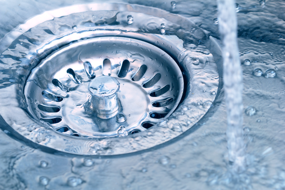 Close up of water going down kitchen sink drain.