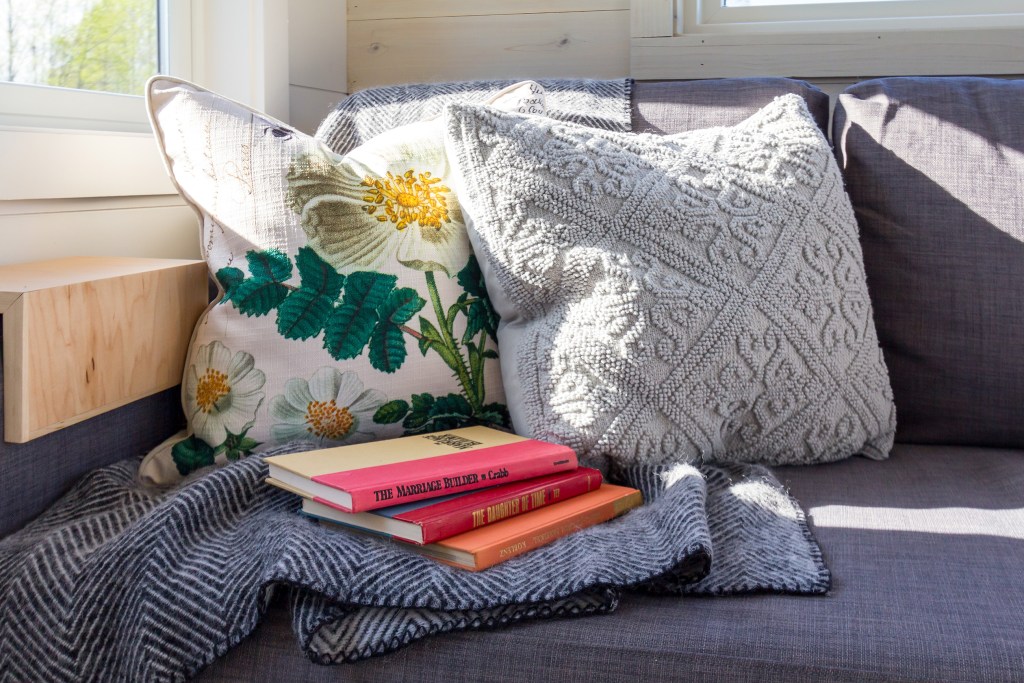 Textured throw pillows on a couch with books