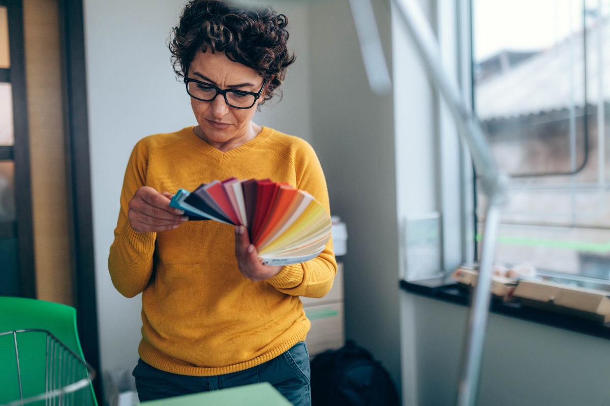 woman holding and looking at interior design color swatches