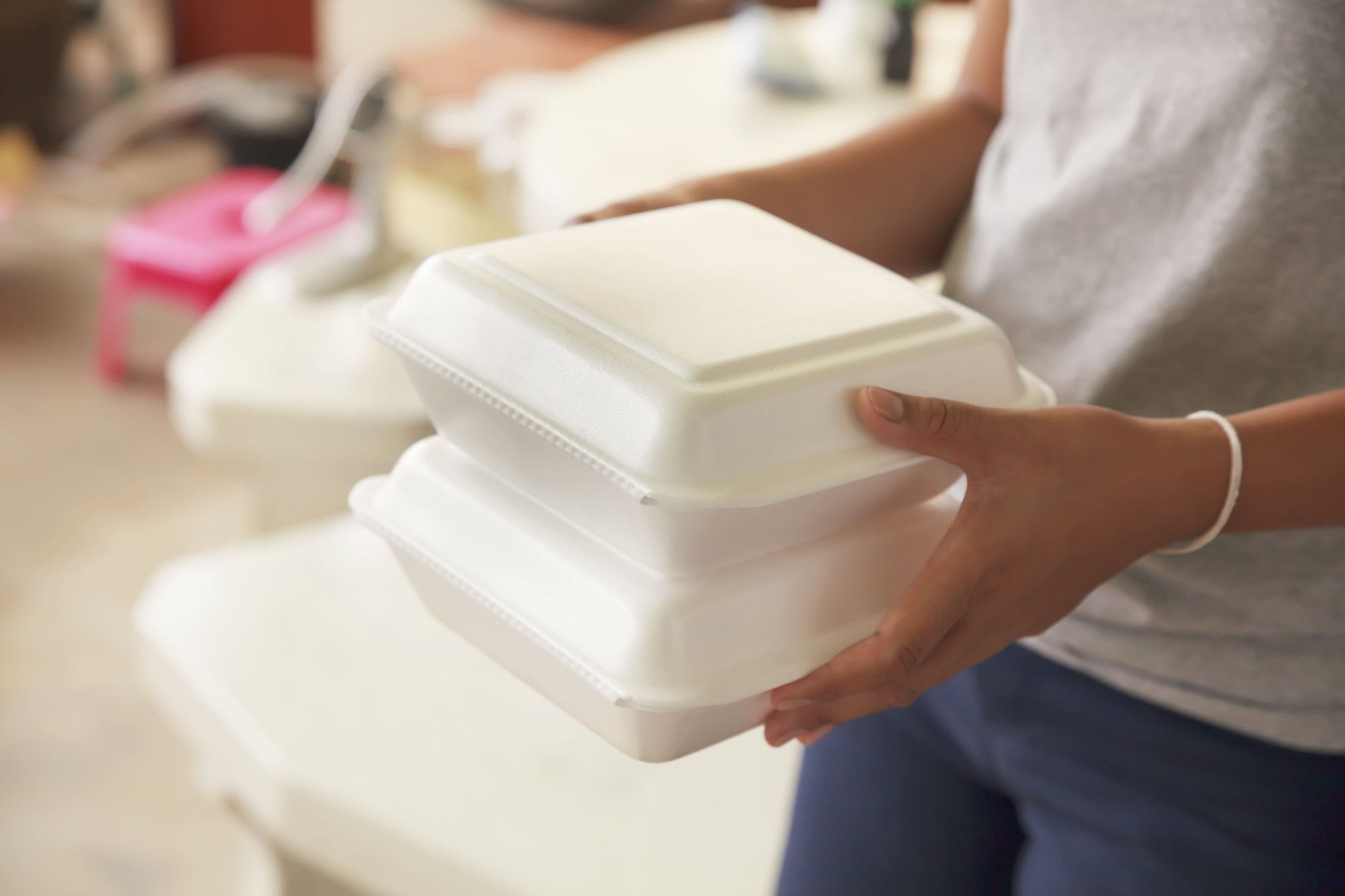 Person holding two Styrofoam containers