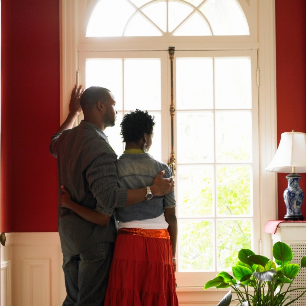 couple standing in front of window in a red painted room