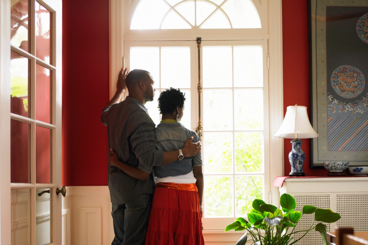 couple standing in front of window in a red painted room