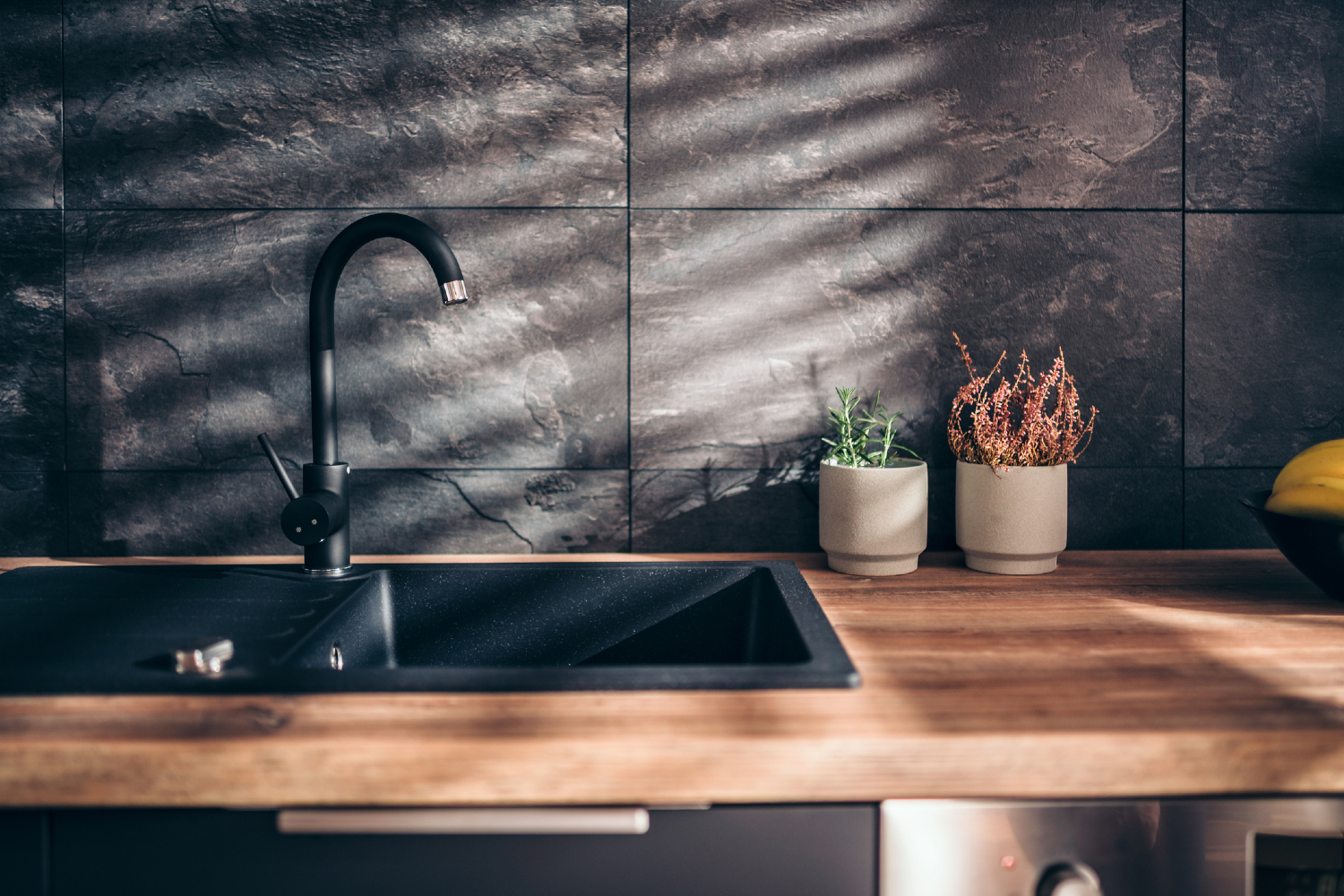 Dark, larger tiles kitchen backsplash.