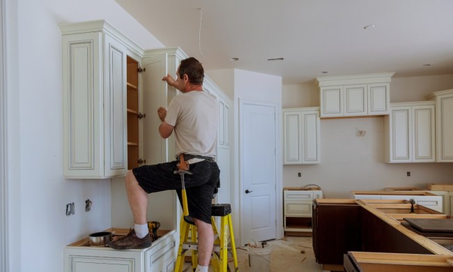 Man installing white kitchen cabinets
