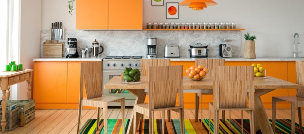 Orange and wood kitchen cabinets in brightly colored kitchen