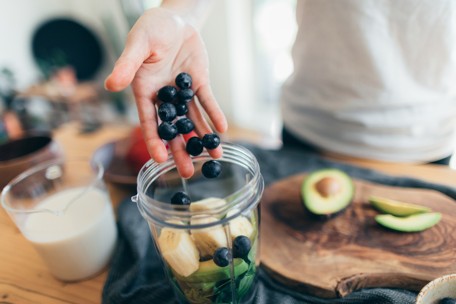 Person making smoothie with fruits.