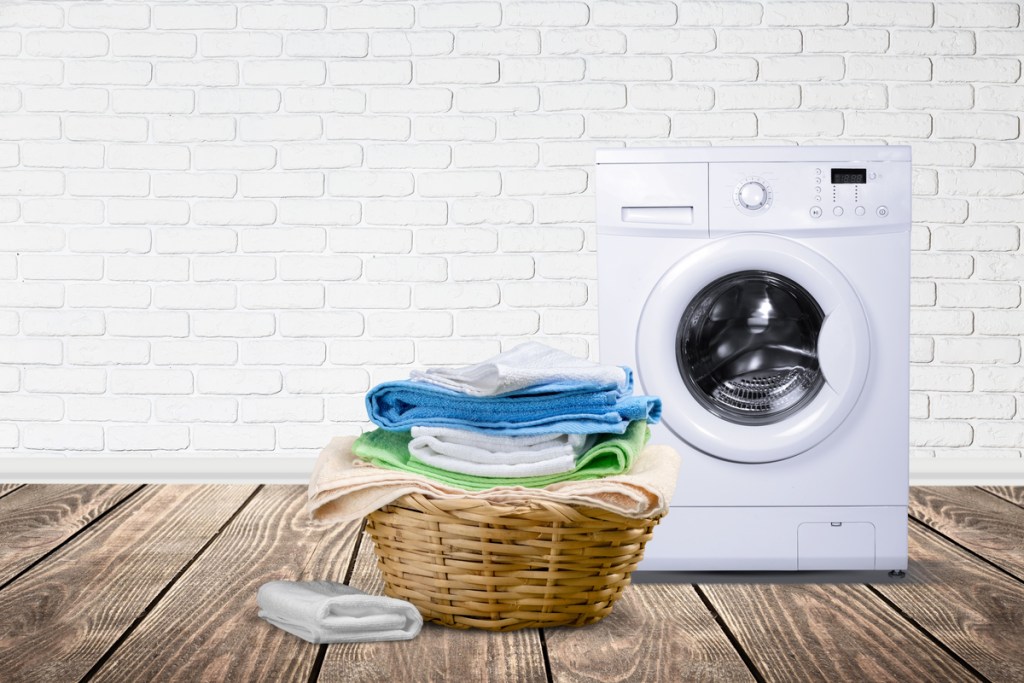 Wicker laundry basket with multi-colored towels in laundry room