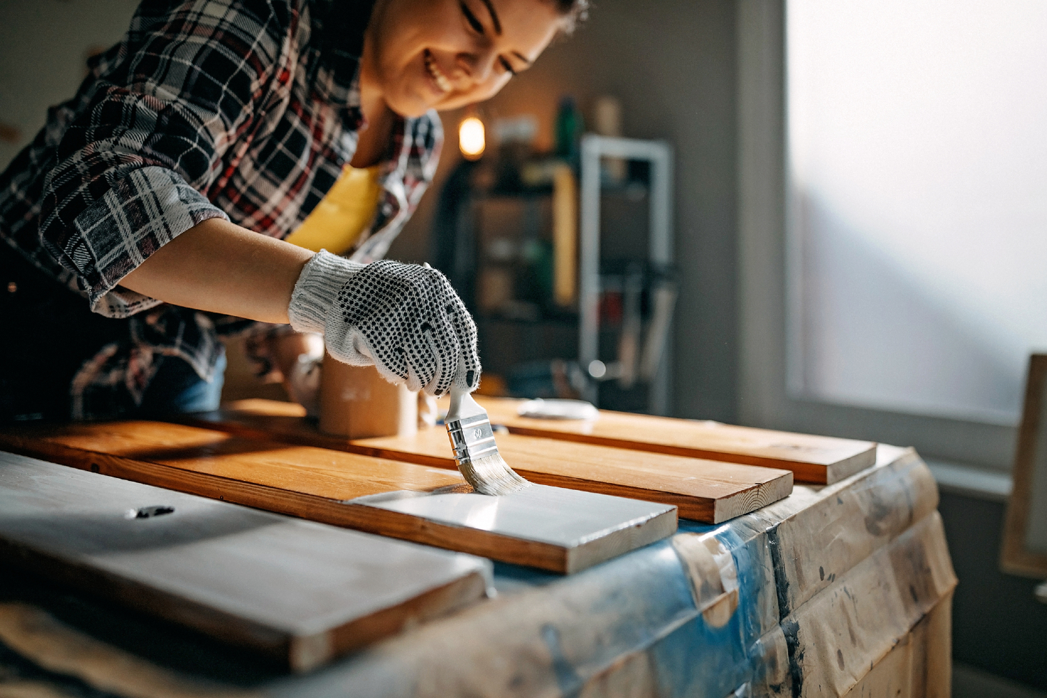 Woman painting wood inside.
