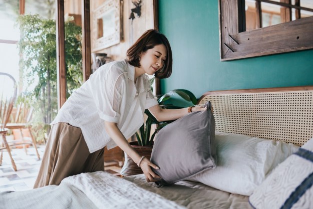 Woman placing a pillow on bed for cohesive design