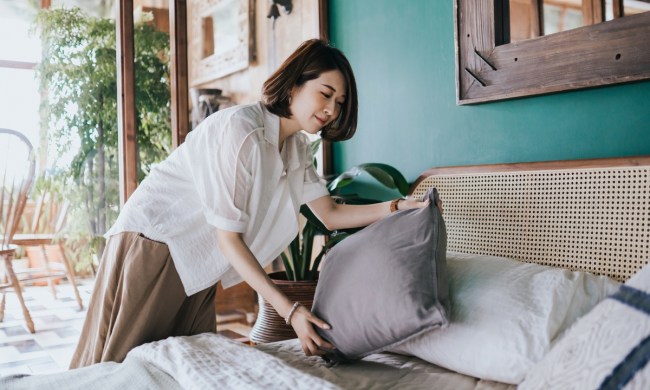 Woman placing a pillow on bed for cohesive design