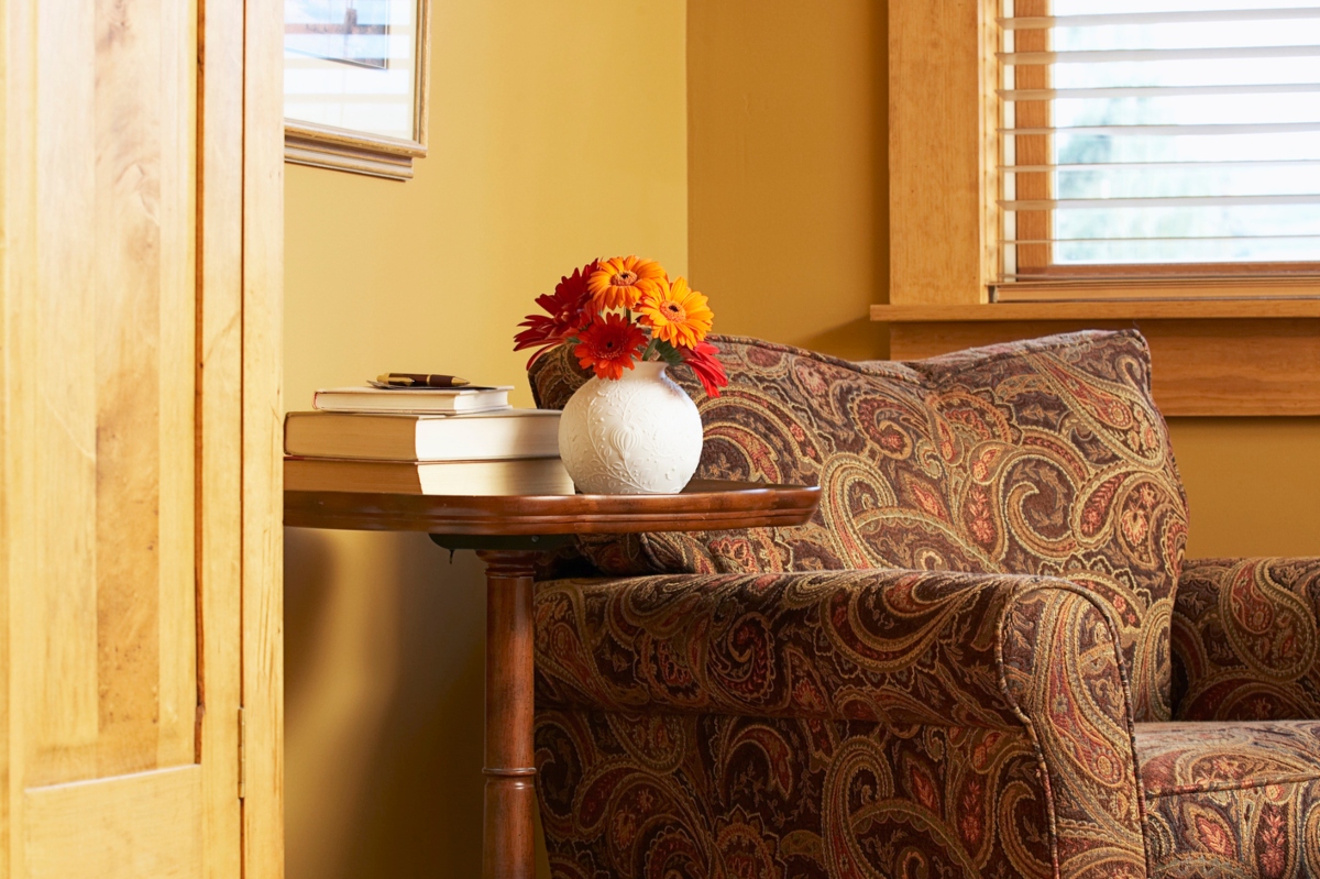 Grandmillenial vintage floral chair design alongside vase and side table