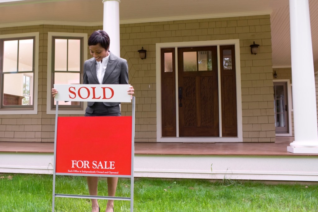 Home with for sale sign and realtor