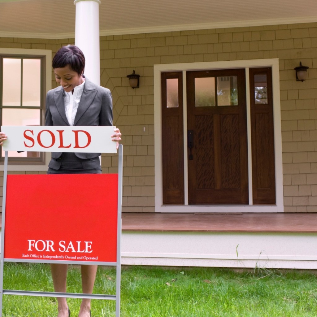 Home with for sale sign and realtor