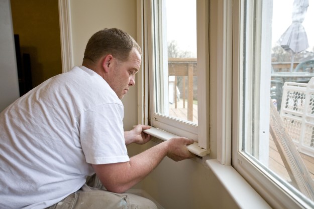 Man installing bottom of window trim