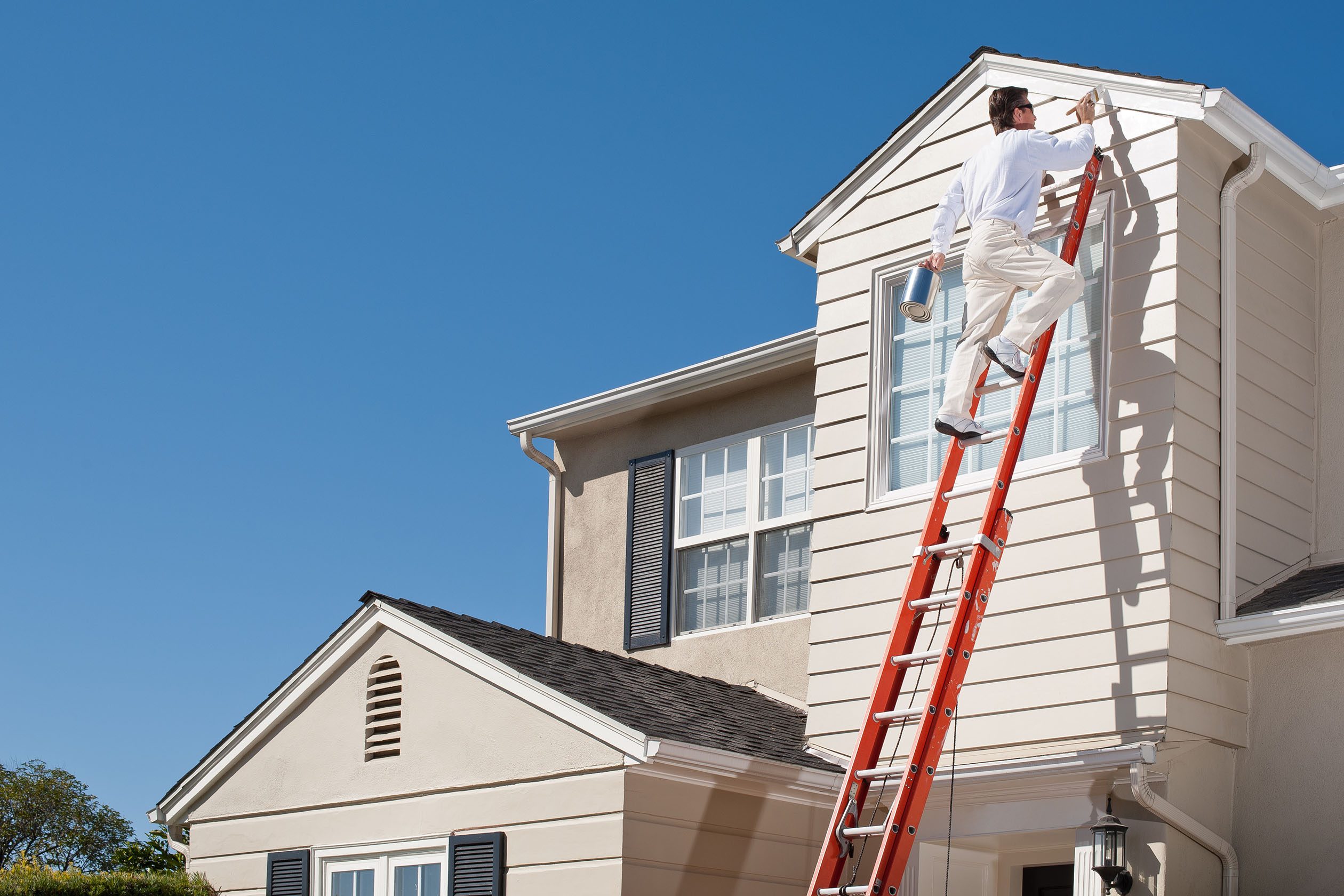 Professional painter painting a home's second story