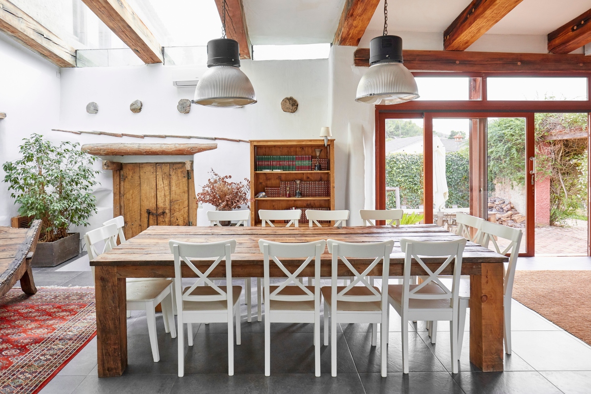 rustic mediterranean kitchen and dining area with wood table and exposed beams