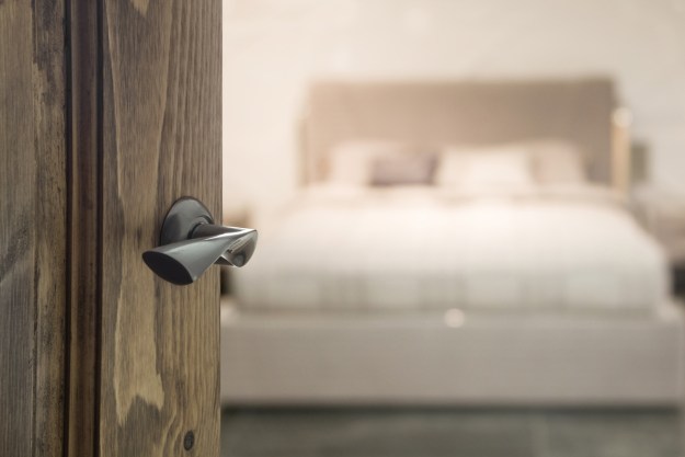 Close-up of door handle with bed out of focus in the background