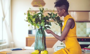 woman arranging flowers in a vase on the table