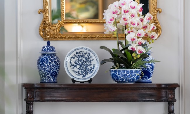 Blue and white porcelain plate decor on entryway table with flowers