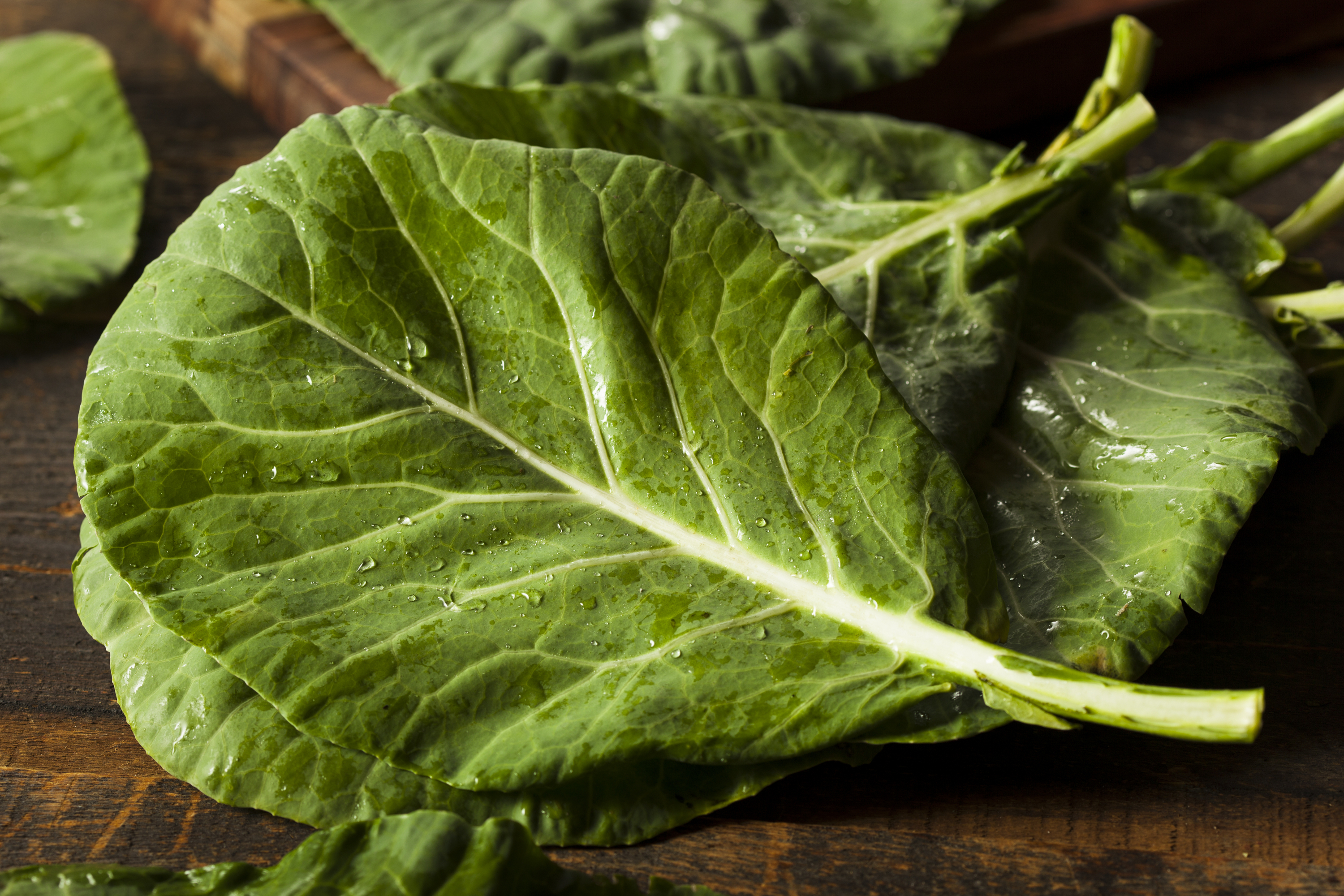 Collard greens on wood background