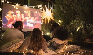 Friends watching a video outdoors using a projector