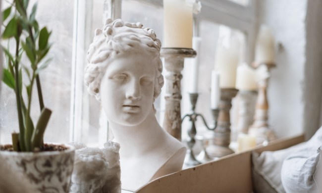 hellenistic greek statue bust on windowsill with candles