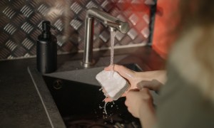 Person washing dishes with a sponge
