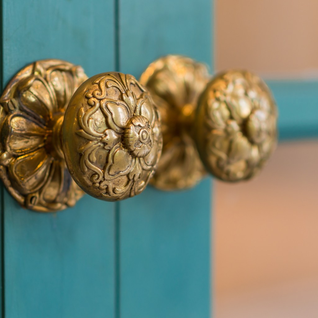 brass handles on teal cabinet doors