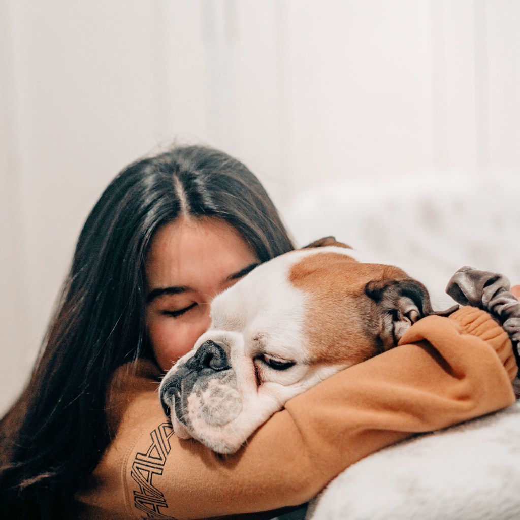 Woman hugging her sleepy dog