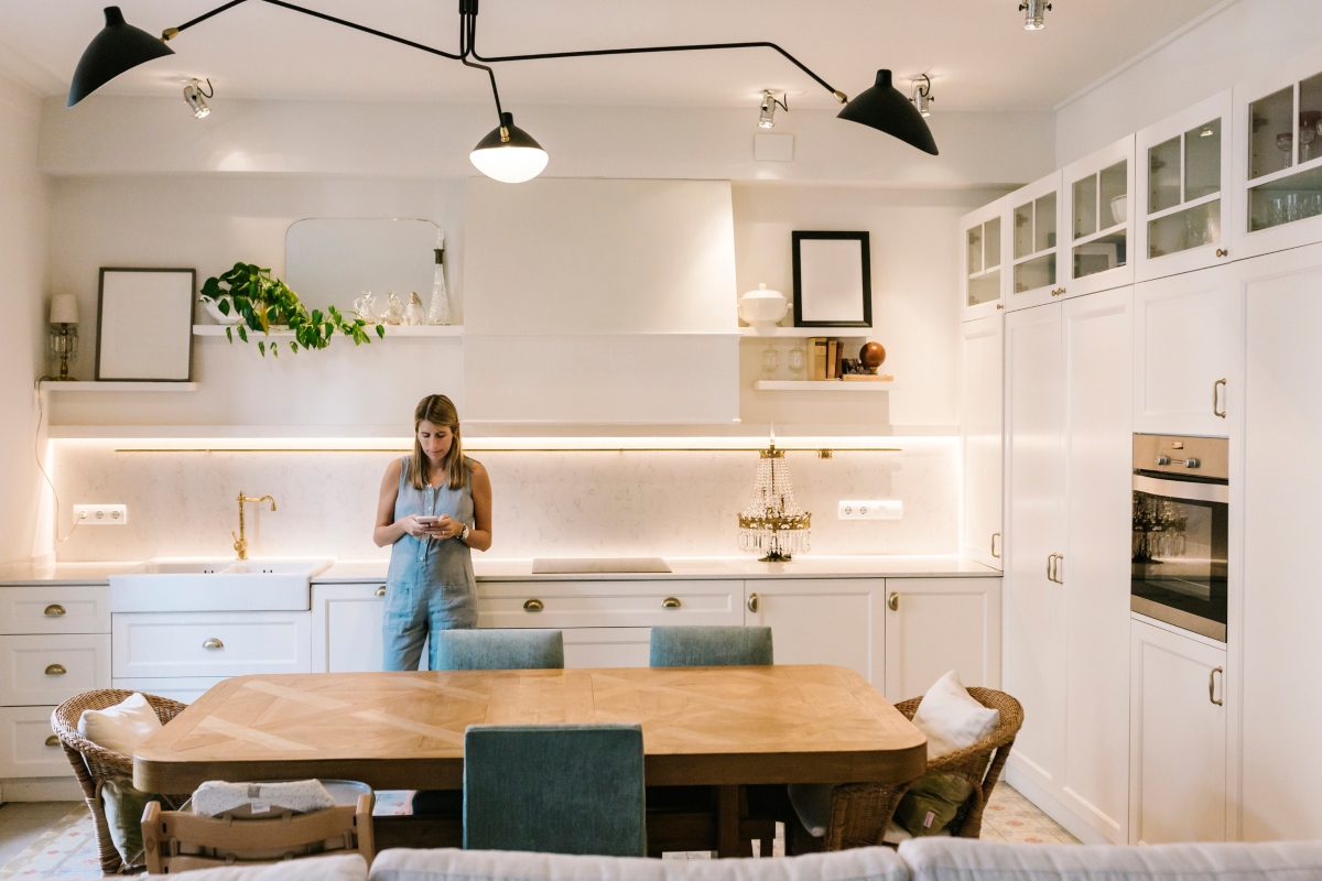 Woman standing in modern kitchen with unique light fixture