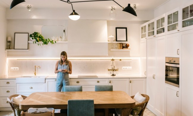 Woman standing in modern kitchen with unique light fixture