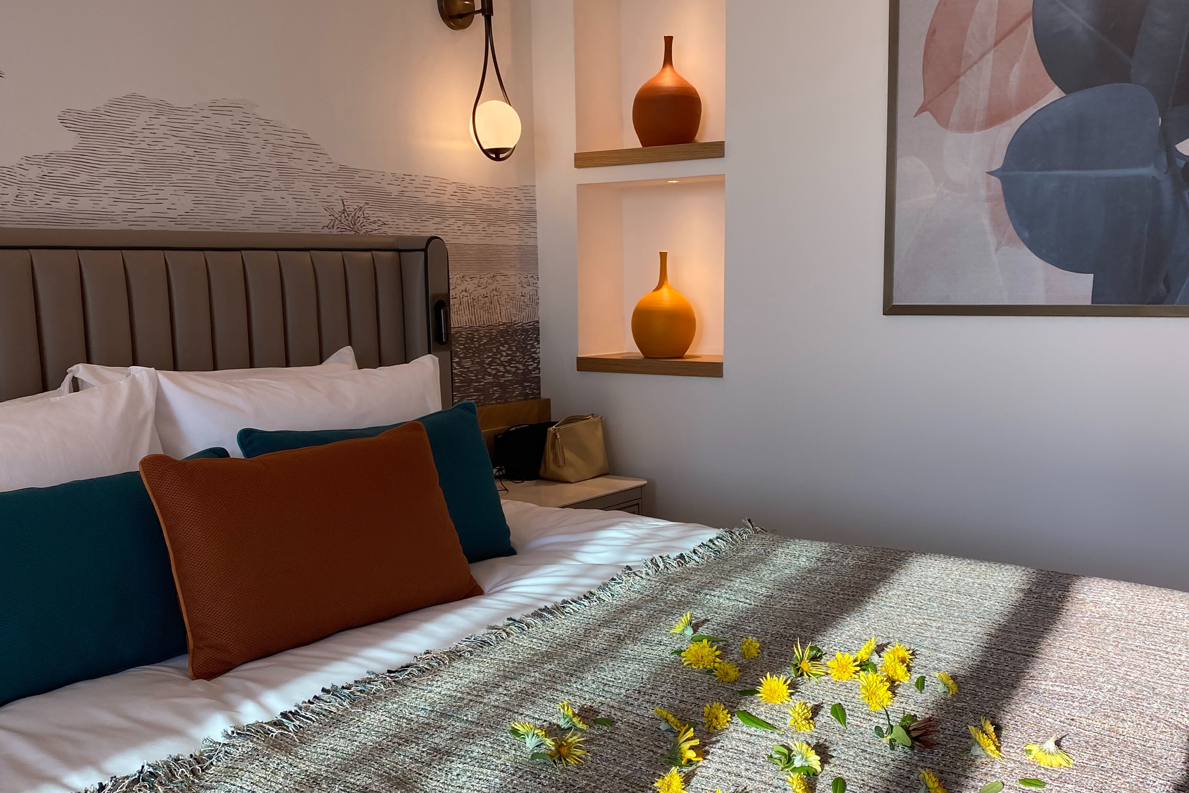 Bed pushed up against a wall with flowers on it