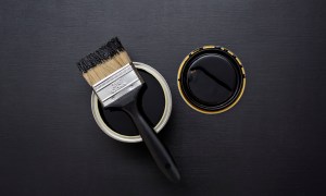 Can of black paint with a paintbrush