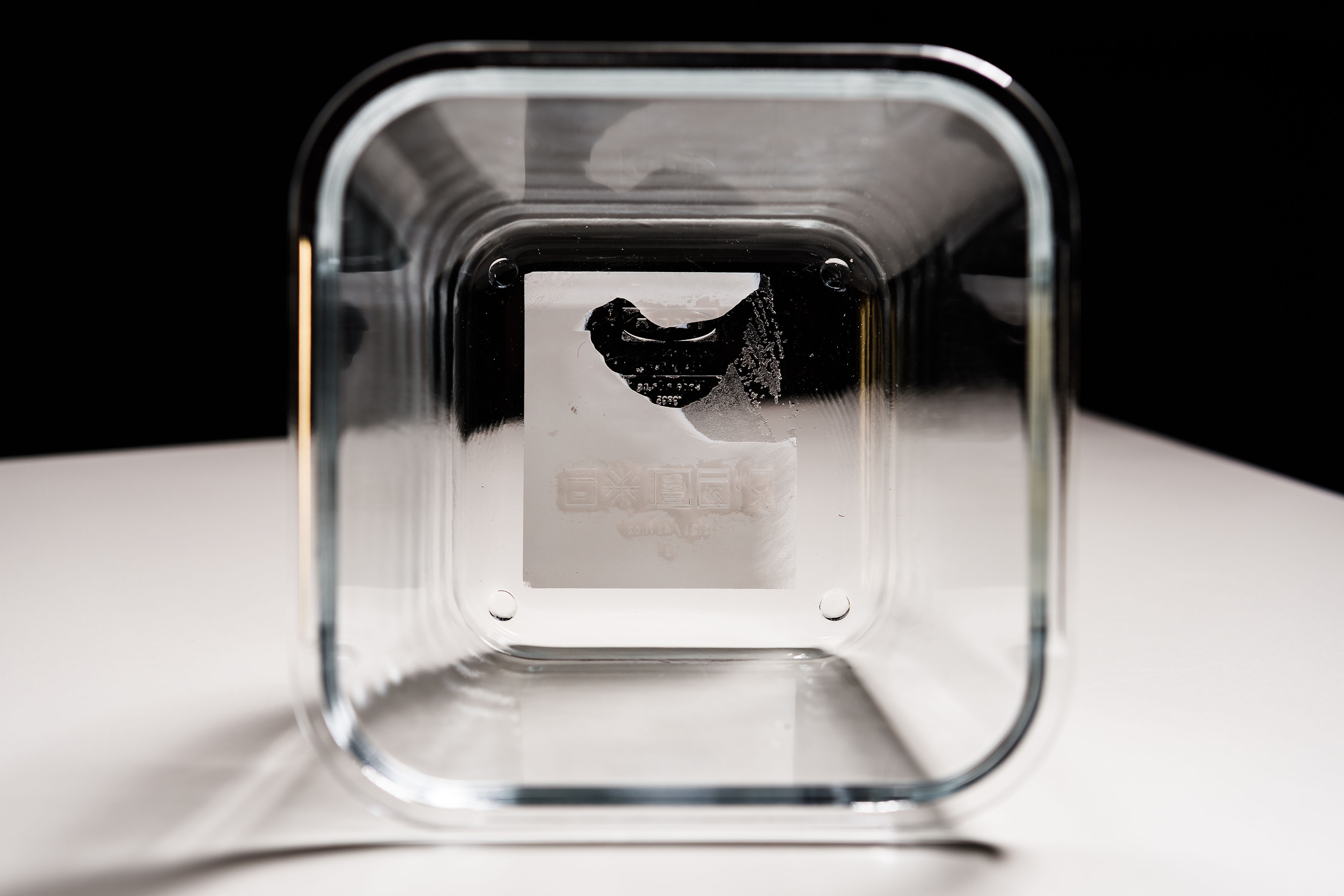 Clear plastic container with half-removed sticker