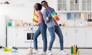 Family pretending to sing with cleaning equipment