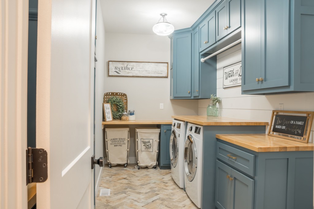 Farmhouse style laundry room with blue cabinets