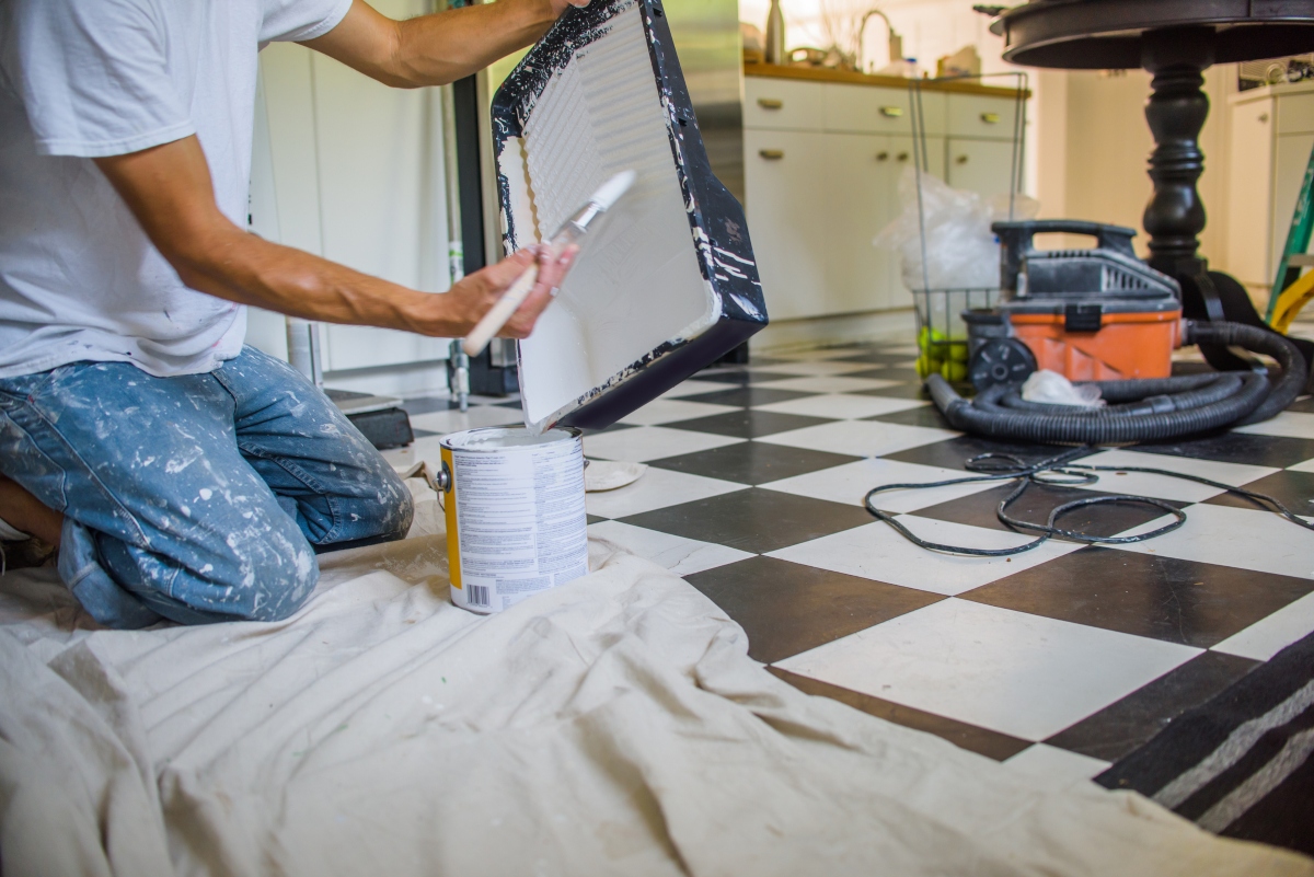 Person painting kitchen tile with DIY method