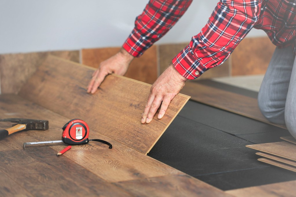 Person installing vinyl flooring planks