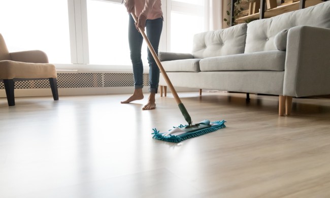 Woman with bare feet cleaning laminate floor with swiffer style mop