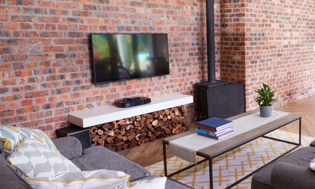 TV mounted on exposed brick wall with a sitting area