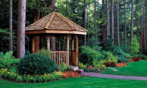 Wooden gazebo surrounded by flowers and trees