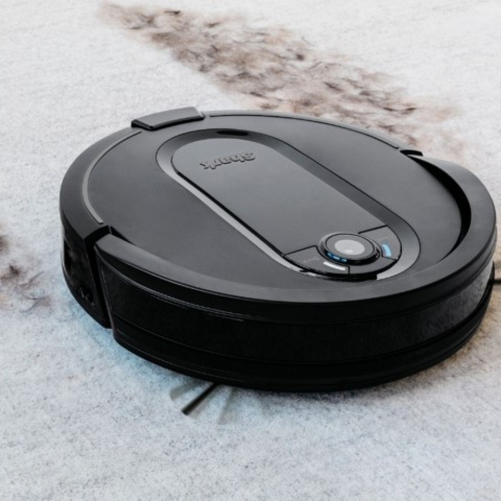 Shark IQ robot vacuum cleaning dirt from white carpet