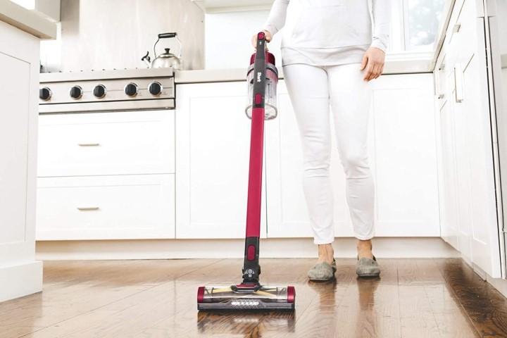 Woman using Shark cordless vacuum in kitchen