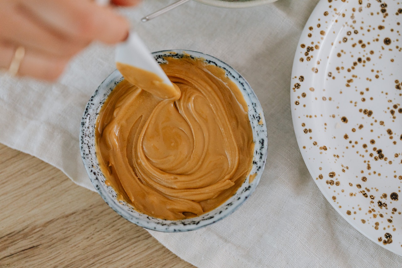 Stirring smooth peanut butter in a small bowl