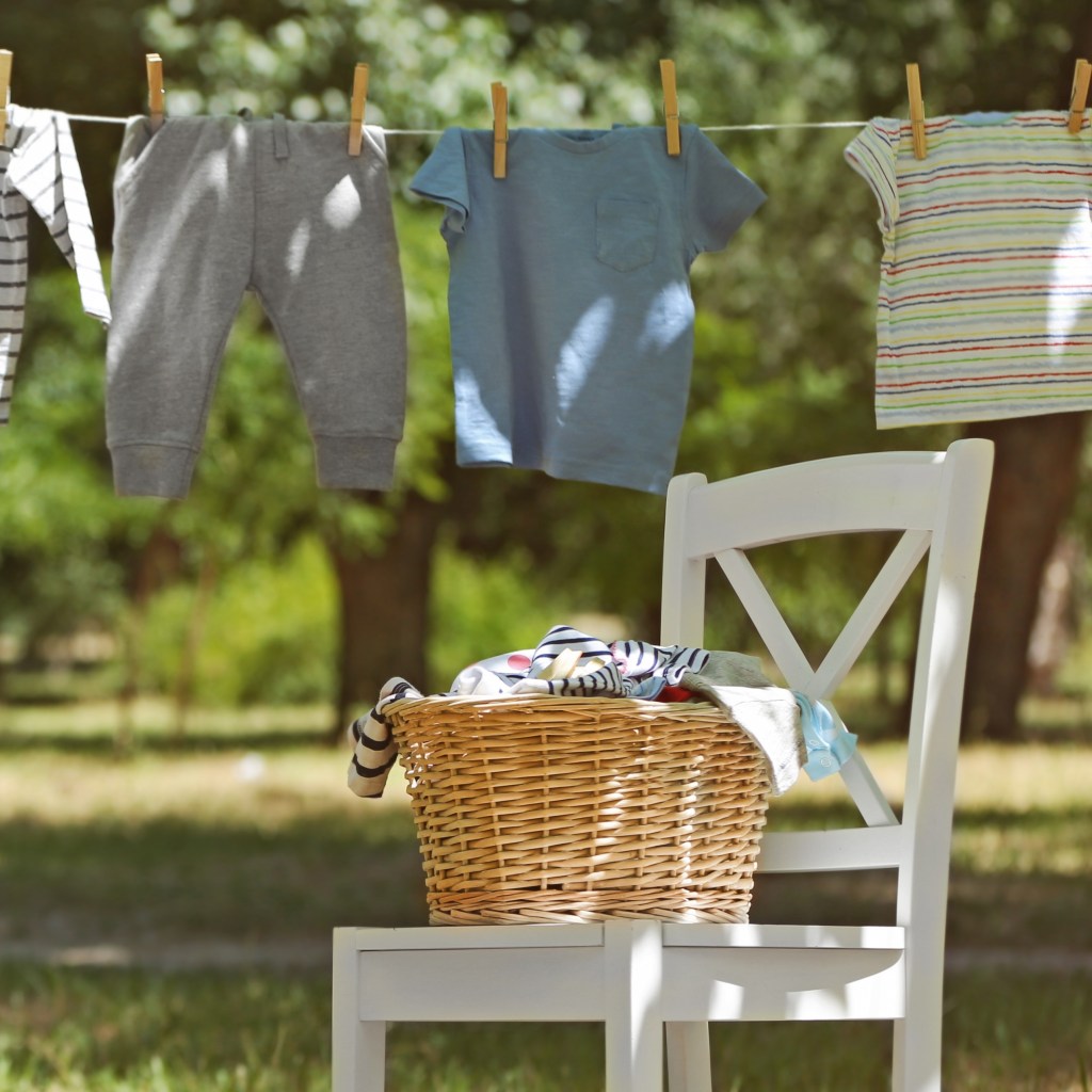 clothing on clothesline next to white chair and wicker basket