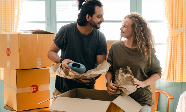 Couple packing moving boxes together